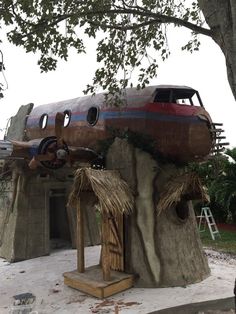 an old airplane sitting on top of a tree stump