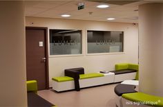 an empty waiting room with green and white furniture