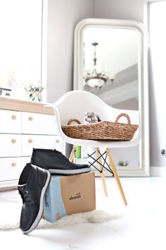 shoes are sitting on the floor in front of a mirror and dresser with a basket