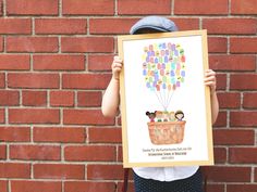 a child holding up a poster with balloons