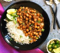 a black plate topped with rice and chickpeas