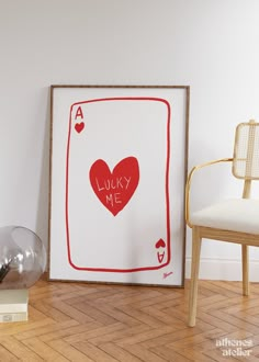 there is a picture frame with a heart on it next to a chair and lamp