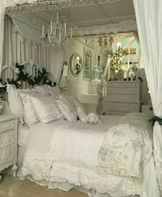 a white bed sitting under a canopy next to a dresser and mirror in a room