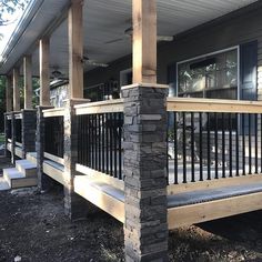 the front porch is made out of wood and has metal railings on both sides