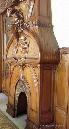 an ornate wooden fireplace with carvings on the mantle