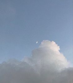 the sky is very cloudy and there are clouds in front of it with a half moon