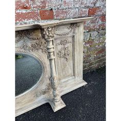 an old white painted dresser with mirror on top and brick wall in the back ground