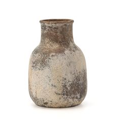 a white and brown vase sitting on top of a table