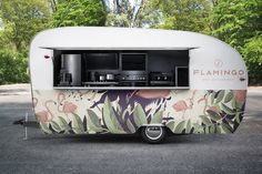 an rv parked in a parking lot with the door open to it's kitchen area