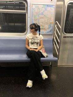 a woman sitting on a subway train with her head in the window