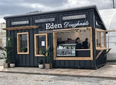 a small black building with people sitting at the counter