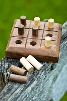 a wooden board game sitting on top of a piece of wood