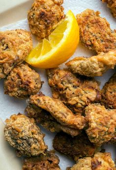 some fried food on a plate with a lemon wedge