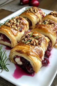 cranberry and pecan roll on a white plate with rosemary garnish