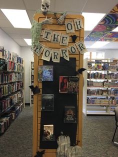 there is a sign that says oh the horror on it and some bookshelves in the background