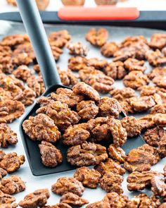 a pan filled with granola sitting on top of a table next to an orange spatula