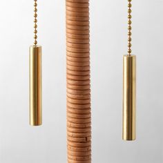 three brass objects hanging from wooden poles