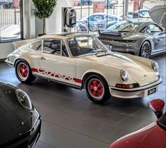 two porsches are parked in a showroom