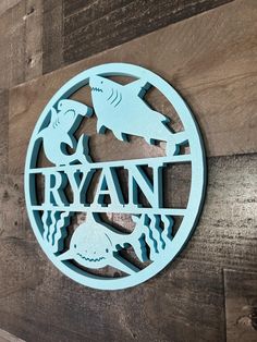 a circular metal sign that says ryan on the side of a wooden planked wall