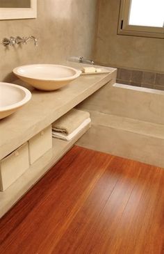 two white sinks sitting on top of a wooden counter next to a bathtub and shower