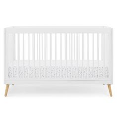 a white crib with wooden legs