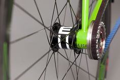 the front wheel of a bicycle with green spokes