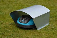 a robotic lawn mower in the middle of a grassy area with it's door open