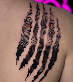 a man's chest with a tiger and claws tattoo on the back of his shoulder