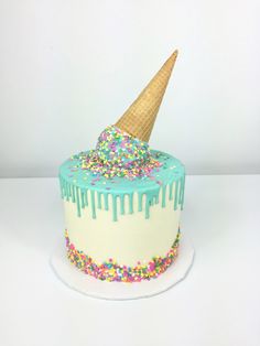 a birthday cake decorated with sprinkles and an ice cream cone on top