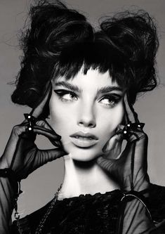 a black and white photo of a woman's face with her hands on her head