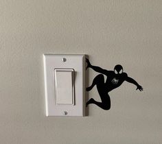 a wall mounted light switch with a spiderman decal on it