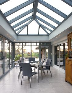 a dining room with glass walls and skylights