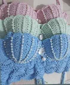 there are many crocheted bras on the bed with pearls and beads in them