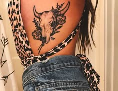 a woman with a cow skull tattoo on her back