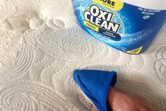 someone cleaning their bed with an oxi - clean cloth on top of the mattress