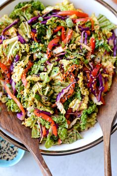 a salad with broccoli, red cabbage and carrots in a white bowl