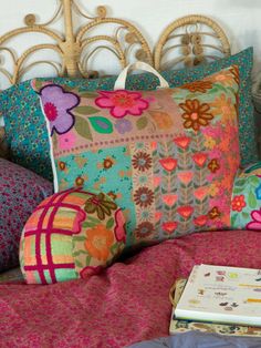 a bed topped with lots of colorful pillows