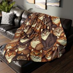 a couch covered in a blanket with cats on it