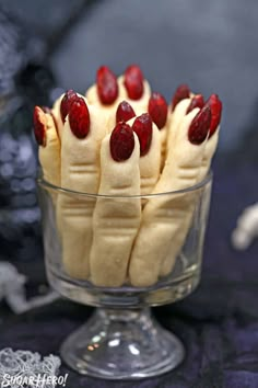 a glass bowl filled with bananas and raspberries on top of a black table