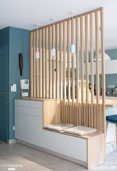 a kitchen with blue walls and wooden slats on the wall, along with white cabinets