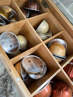 an open wooden box filled with lots of different types of bowls and spoons in it