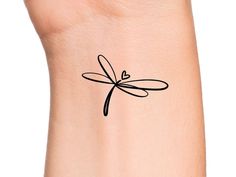 a small wrist tattoo with a dragonfly on it