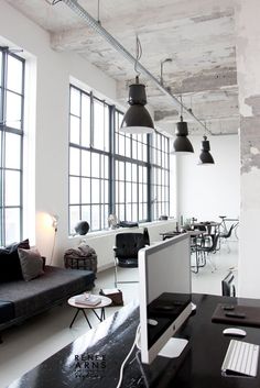 an office with black and white furniture and large windows