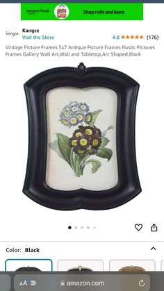 an ornate black frame with flowers painted on the front and bottom, is shown in this image