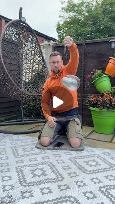 a man is sitting on the ground with some pots