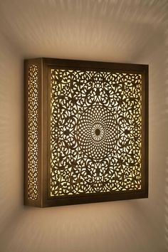 an intricately designed wall light in the shape of a square with a circular design on it