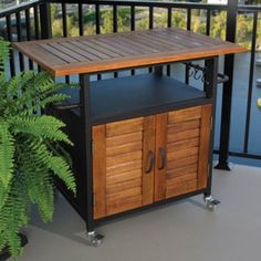 a wooden table sitting on top of a balcony next to a potted green plant