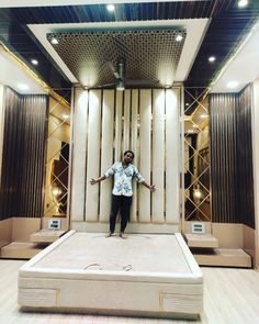 a man standing on top of a bed in a room with wooden floors and walls