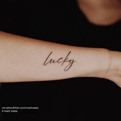 a woman's arm with the word lucky tattooed on it