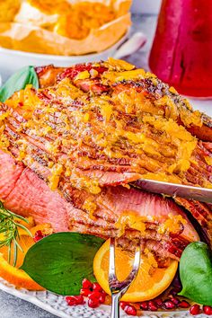 a large piece of meat sitting on top of a plate next to oranges and cranberries